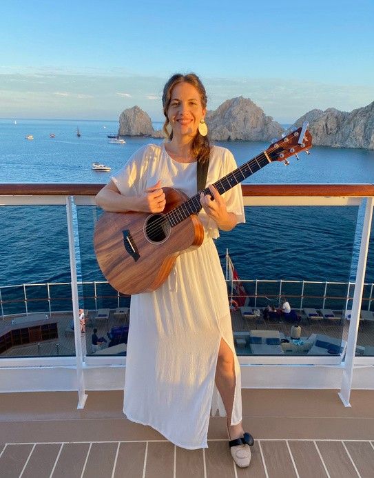 Lisette Luján con su guitarra en la cubierta de un crucero